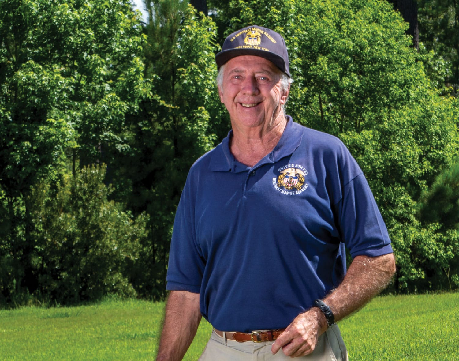 photo-3 An older man in a blue shirt standing in a field.