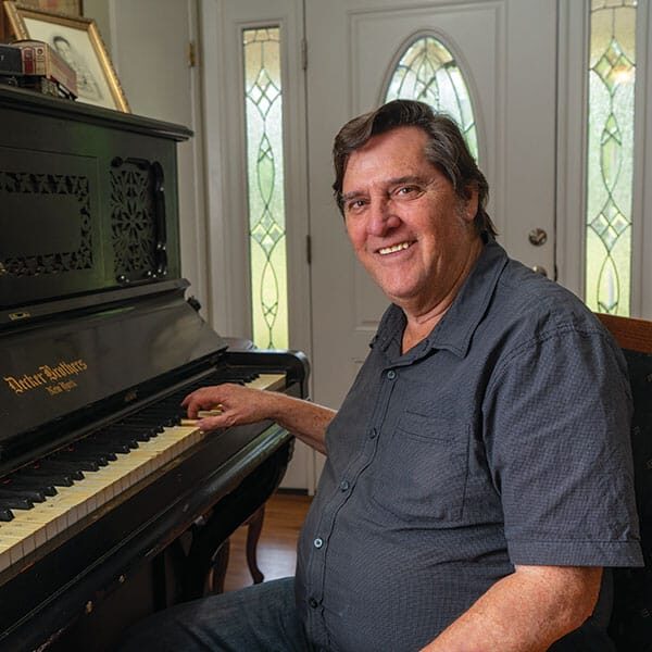 A man sitting in front of a piano.