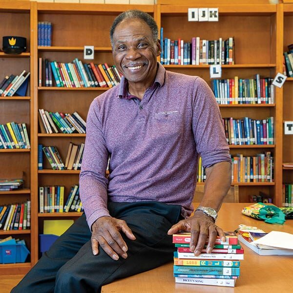 A man sitting at a table with books in front of him. A man sitting at a table with books in front of him.