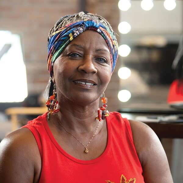 A woman wearing a turban in front of a mirror.