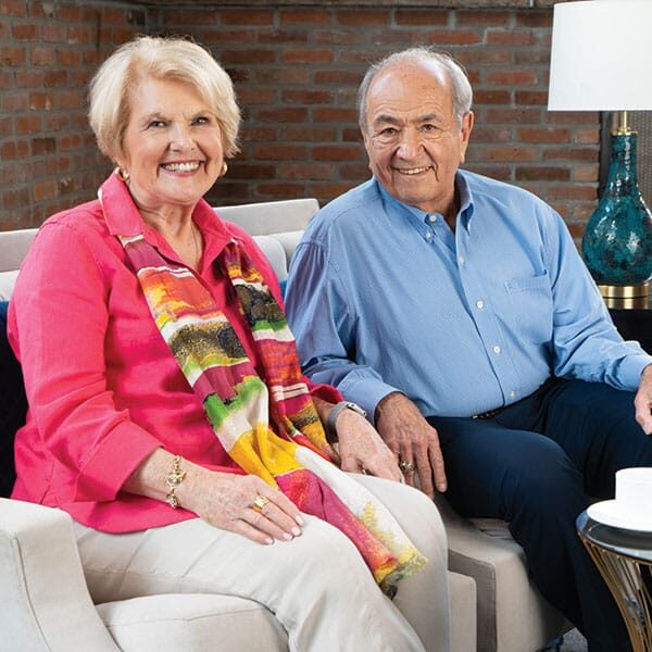 An older couple sitting on a couch with a cup of coffee. An older couple sitting on a couch with a cup of coffee.