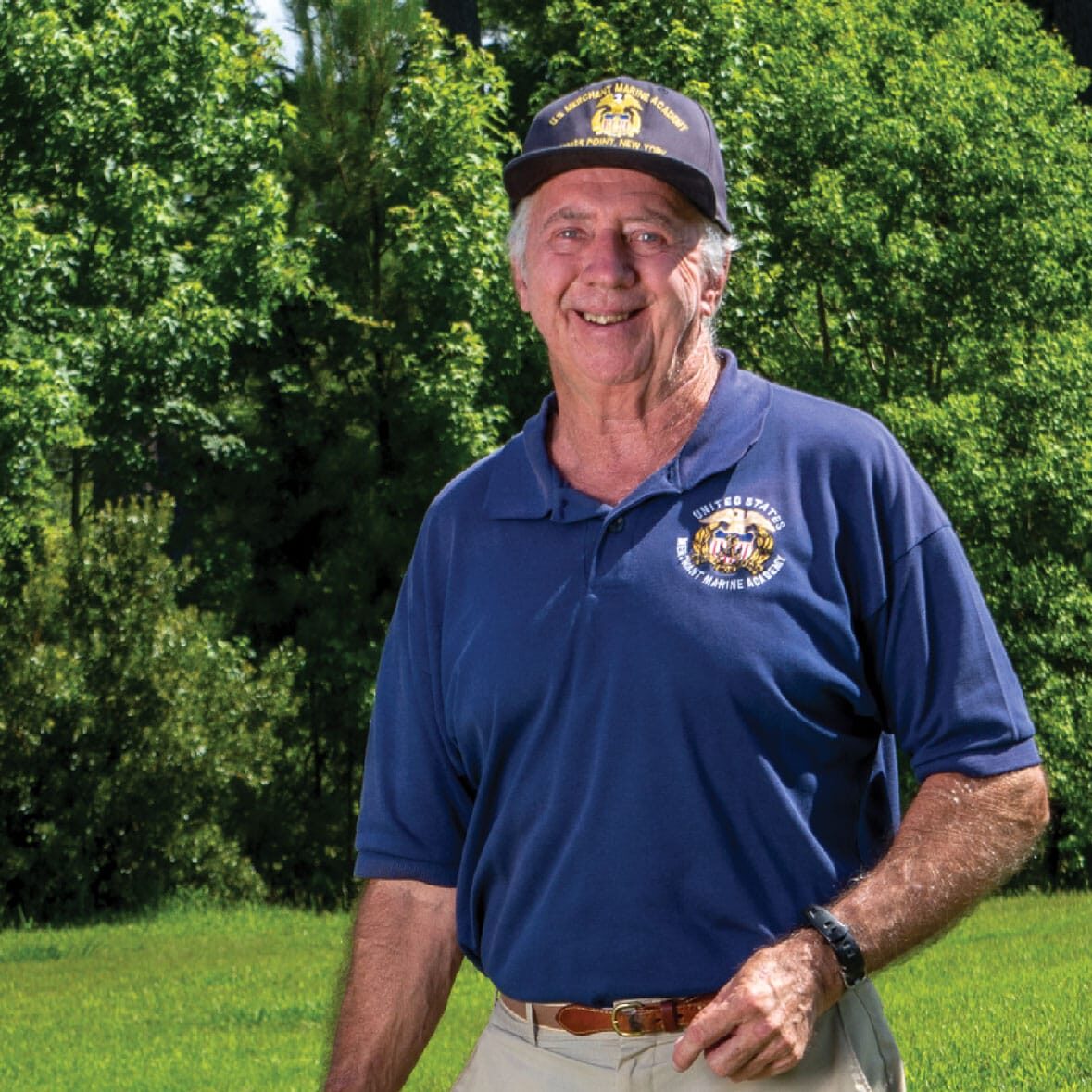 photo-3 An older man in a blue shirt standing in a field.